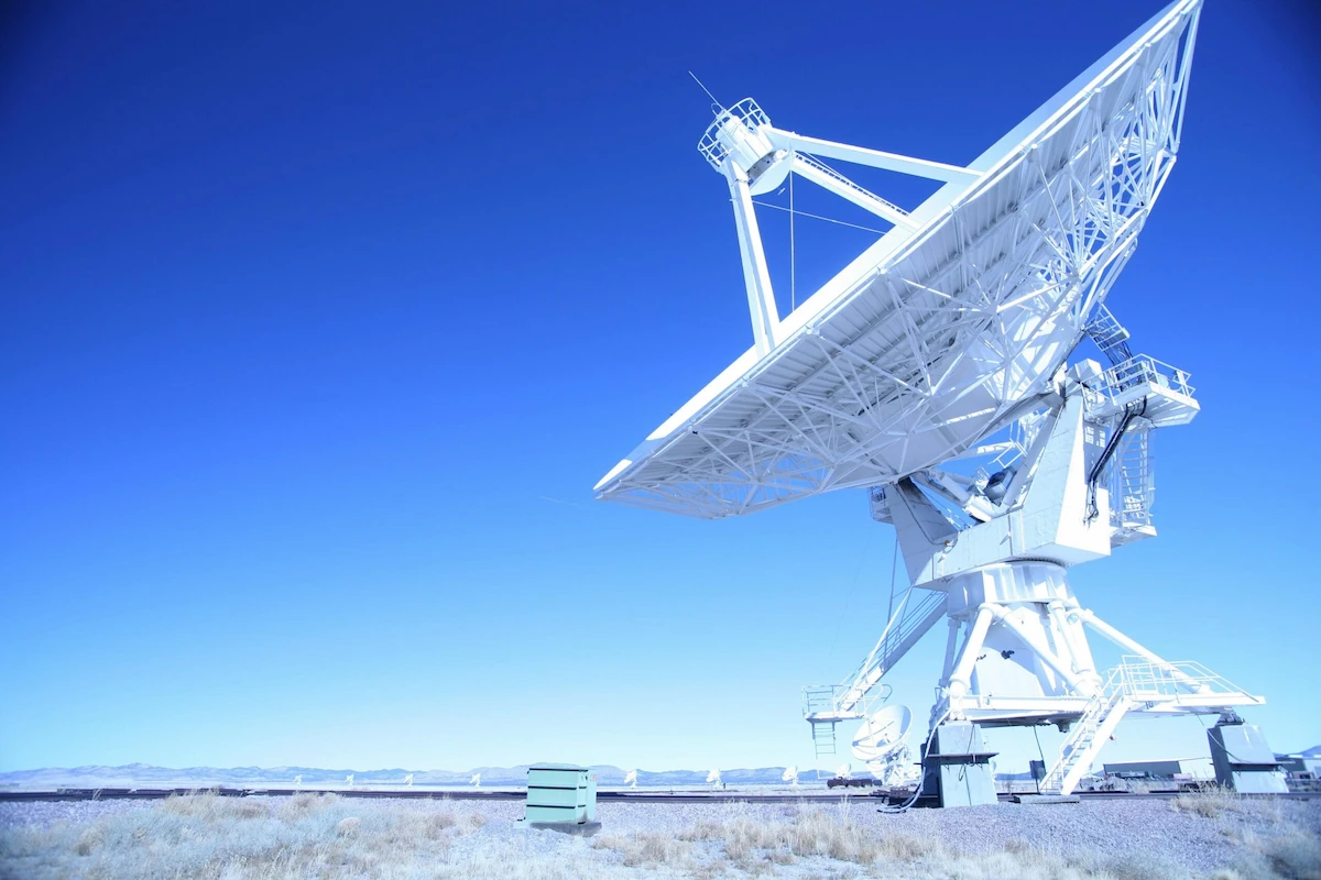 radiotelescoop met grote satellietschotel tegen een blauwe lucht